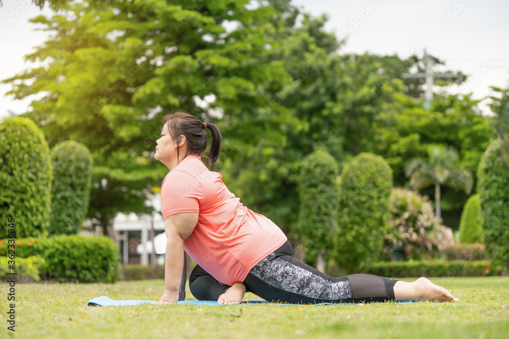 new normal concept,Young woman is happy to motivation exercise or yoga outdoor in the garden to control or lose weight.Obese fat woman have intention exercise to lose weight and build strong health.