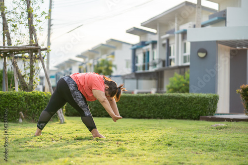 new normal concept,Young woman is happy to motivation exercise or yoga outdoor in the garden to control or lose weight.Obese fat woman have intention exercise to lose weight and build strong health.