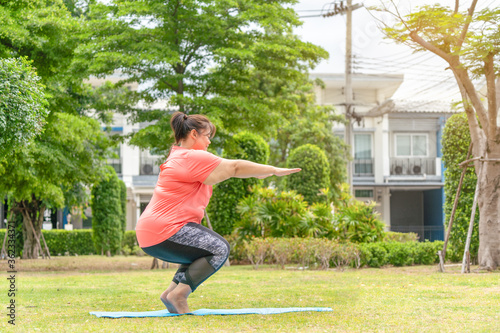 new normal concept,Young woman is happy to motivation exercise or yoga outdoor in the garden to control or lose weight.Obese fat woman have intention exercise to lose weight and build strong health.