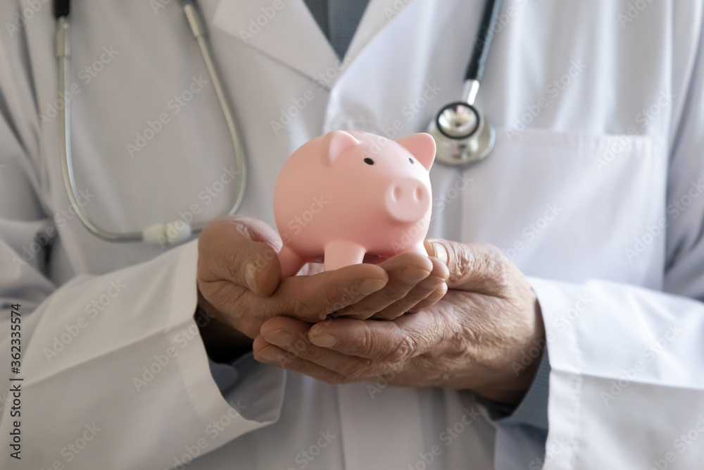 Close up of male doctor in white medical uniform hold piggybank ask about volunteer money donation for hospital or clinic, man GP collect charity contribution for patient care, healthcare concept Close up of male doctor in white medical uniform hold piggybank ask about volunteer money donation for hospital or clinic, man GP collect charity contribution for patient care, healthcare concept