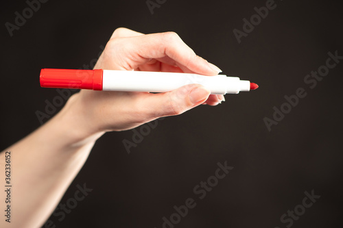 Hand with a red marker on a...