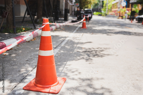 White orange traffic hazard cone on asphalt road repair photo