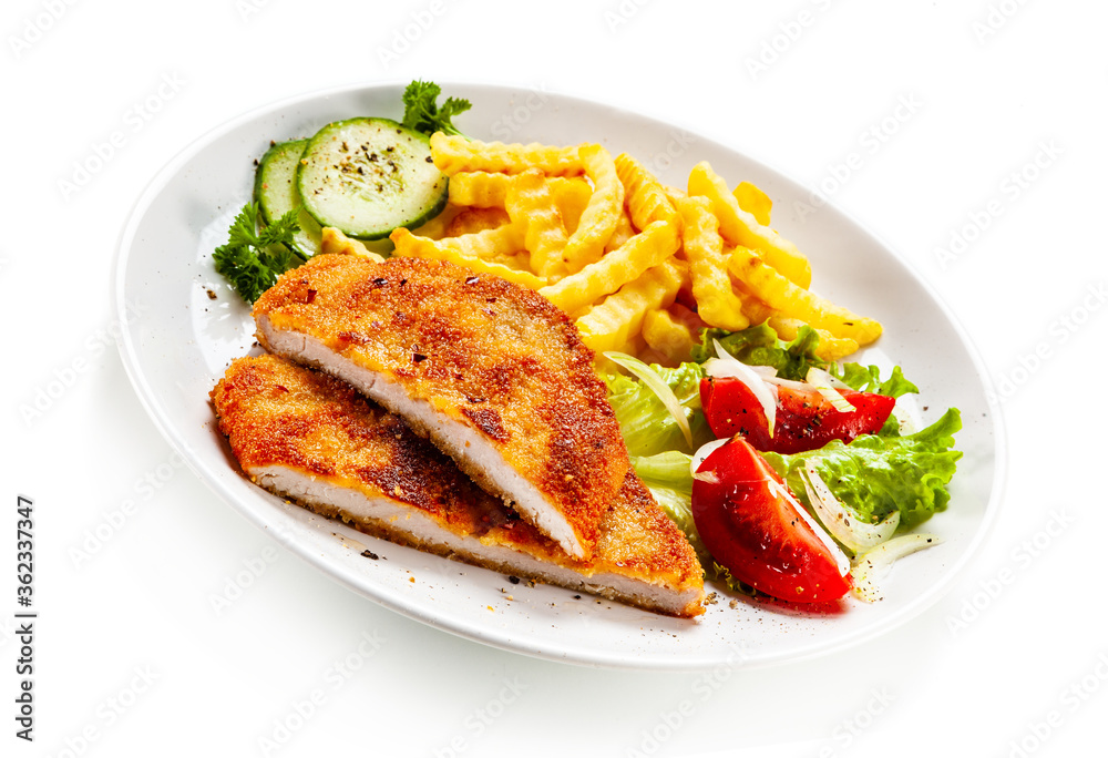 Breaded fried pork chop, French fries and vegetables on white background
Breaded fried pork chop, French fries and vegetables on white background