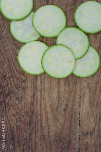 Sliced raw zucchini on a wooden table. Dietary food. Vegetables.