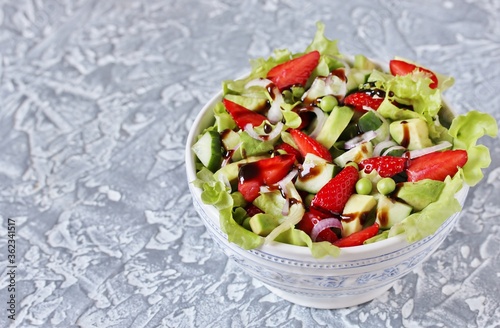 salad with strawberries, avocado, lettuce, onion, green peas. dressed with balsamic sauce.