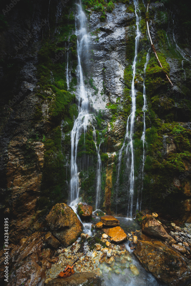 Intimate scene of small waterfall, rocks and moss