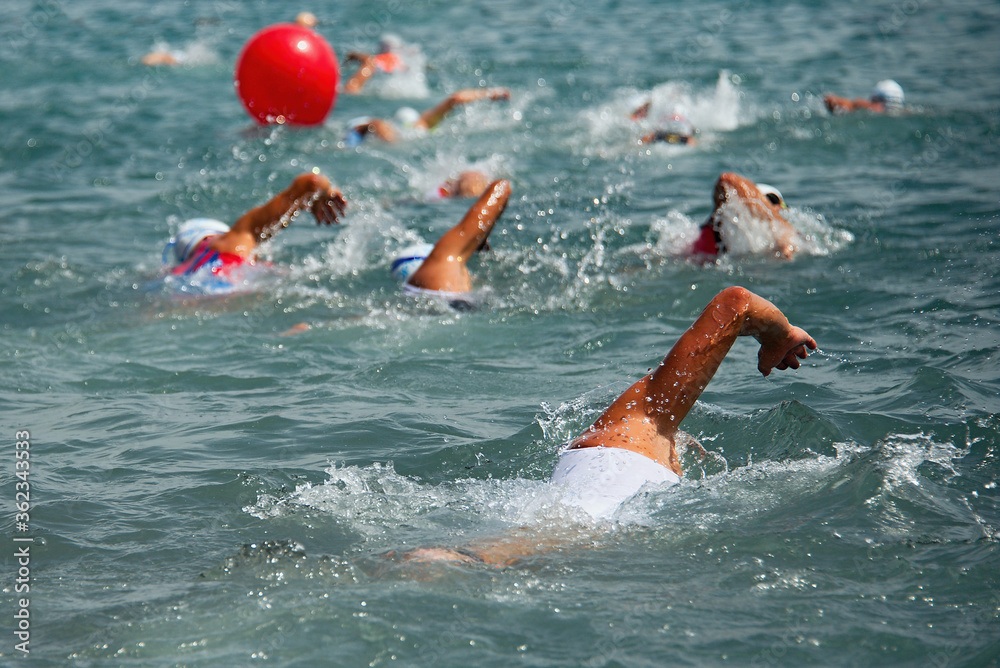 Competitors swimming out into open water at the beginning of triathlon
