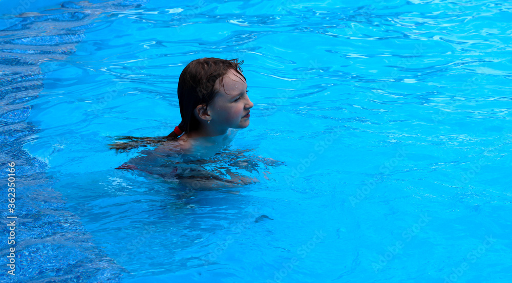 A girl is swimming in the pool.