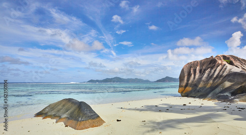 Seychelles landscape waterscape from Anse Source D'argent beach  La Digue over Indian ocean with large granite rocks turquoise water golden sand and blue sky behind white wispy clouds heaven 