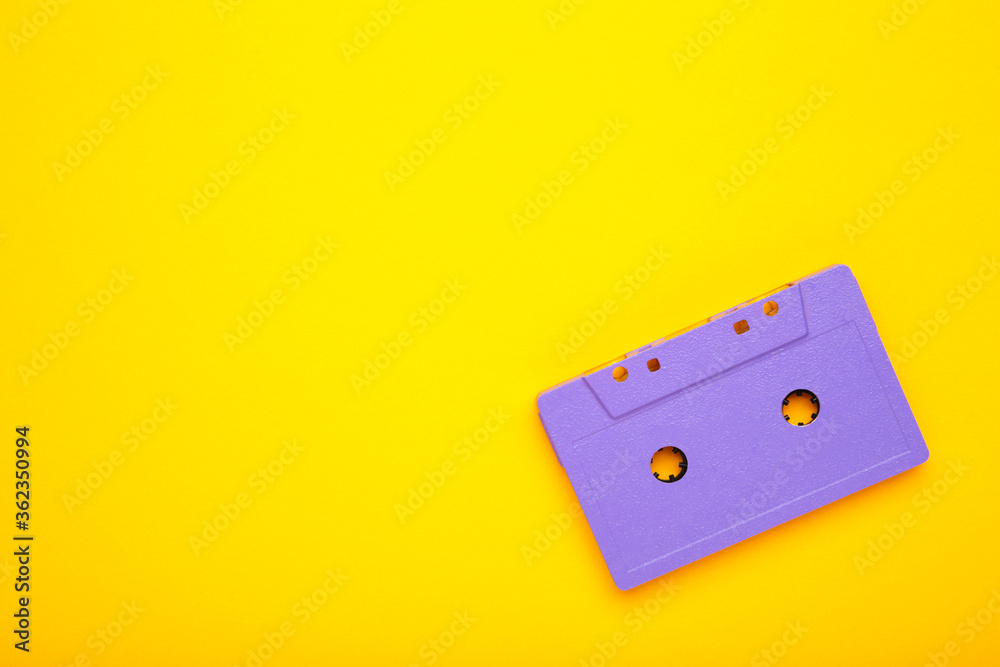 Old violet audio cassette on yellow background with copy space. Music day Old violet audio cassette on yellow background with copy space. Music day
