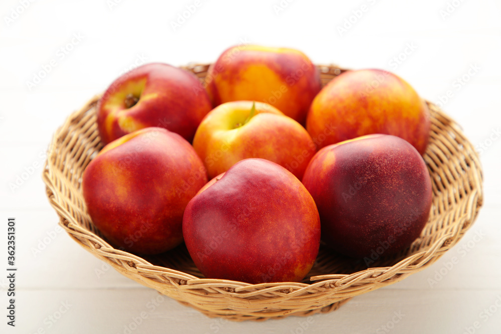 Nectarines in a basket on white background Nectarines in a basket on white background