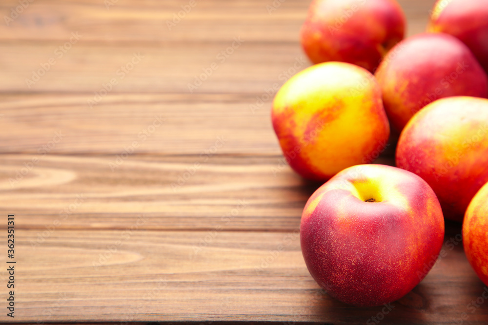 Many nectarines on brown wooden background with copy space