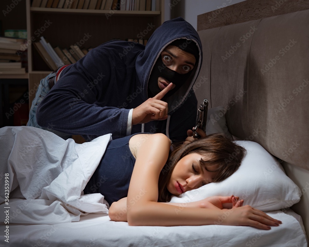 Φωτογραφία Burglar breaking into house at night to bedroom with sleeping wo