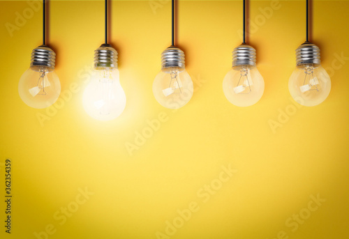 Idea concept. Light bulbs on yellow background, space for text