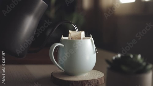 Coffee Drip at Home Concept. Pouring Hot Water from Kettle into a Dripper Bag. Making Hot Coffee Drink in Nature. Zen and Cozy Living