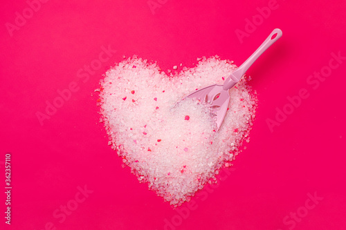 Schilderij op canvas Cat litter, heart shaped bright pink background with a spatula for cleaning poop