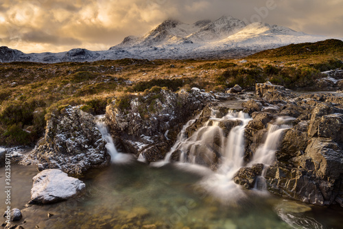 Dramatic clouds on the Isle of Skye with the Cuillin mountain range covered in snow taken from a waterfall near Sligachan bridge. © _Danoz