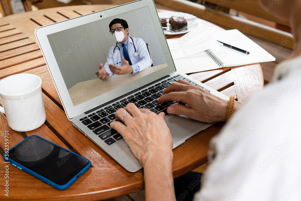 senior asian woman who has health problem using computer to consult doctor via video call conference. healthcare and medical concept