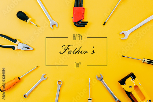 Obraz na płótnie Tools top view on yellow background. Father's day card with tools. Plier, open wrenches, screwdrivers and staple gun in a cirlce. w salonie