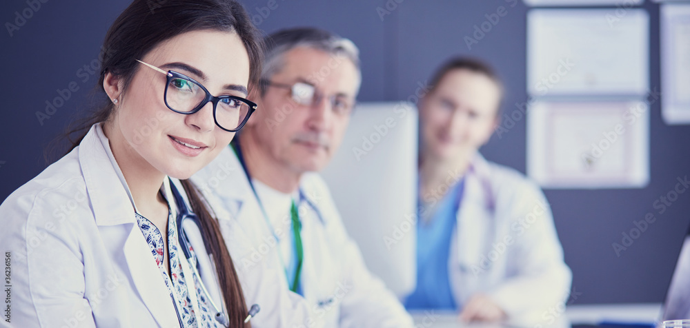 Serious medical team using a laptop in a bright office Serious medical team using a laptop in a bright office