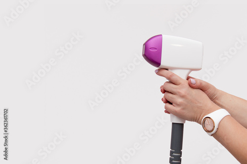 female hands holding laser hair removal on isolated white background. Banner for beauty salon 