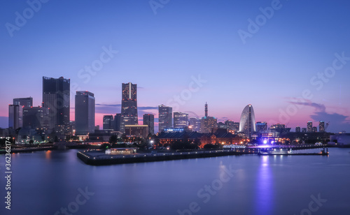 Yokohama, Japan - August 10, 2019: Yokohama Minato Mirai 21 area after sunset. The sky has blue to purple gradation. photo