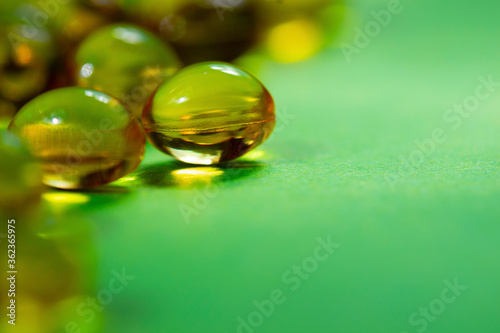 vitamins in capsules are yellow on a green background.close up.the concept of vitamin and mineral deficiency for the health of the body.space for text.