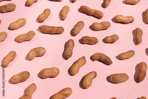 whole peanuts isolated on pink background