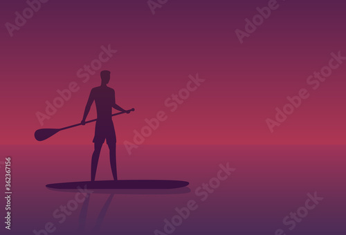 Man on a sup board at sunset