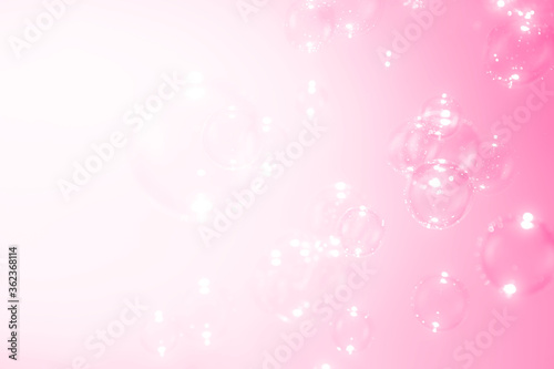 Soap bubbles float on pink background.