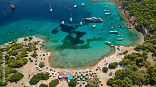 Aerial drone photo of beautiful exotic turquoise sea rocky Mediterranean island forming a blue lagoon visited by sail boats and yachts