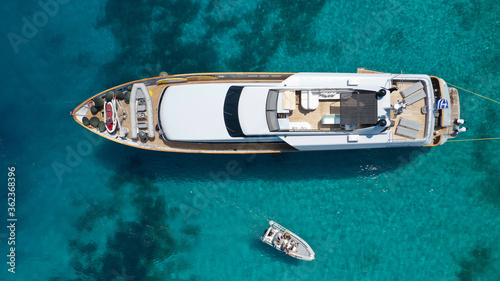 Aerial drone photo of yacht anchored in popular bay and beach of Super Paradise, Mykonos island, Cyclades, Greece © aerial-drone