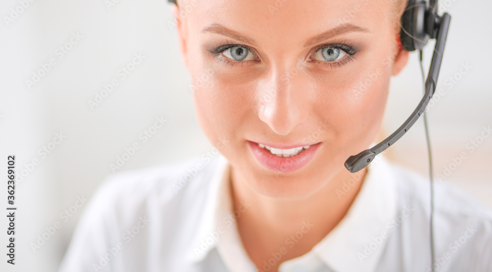 Portrait of pretty young female operator sitting at office desk with headset Portrait of pretty young female operator sitting at office desk with headset