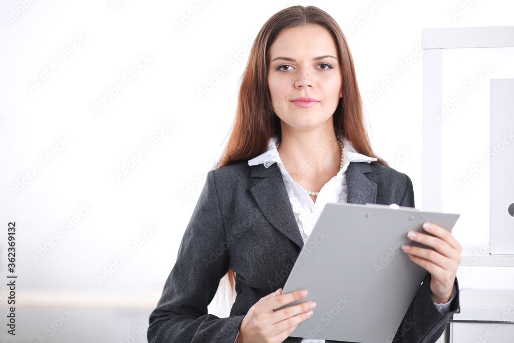 Portrait of business woman standing with crossed arms in office. Portrait of business woman standing with crossed arms in office.