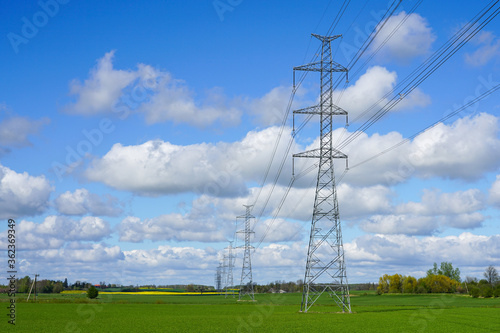 high-voltage power transmission line in a cereal field on a background of blue sky
