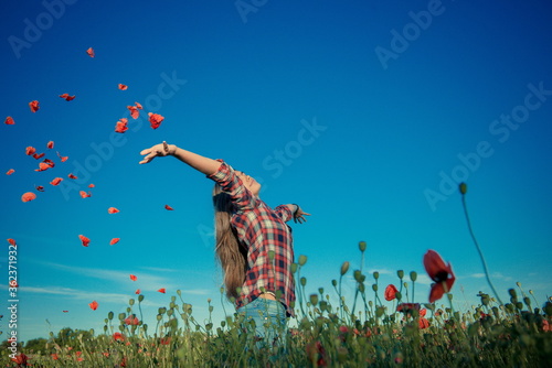happy girl. Beautiful girl in poppy field. Young girl with long hair among the blossoming poppy field. concept of freedom and travel. Poppy buds. Gardening