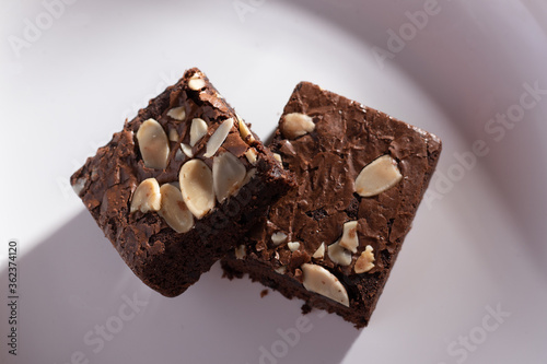 Two almonds brownies on a natural wood background