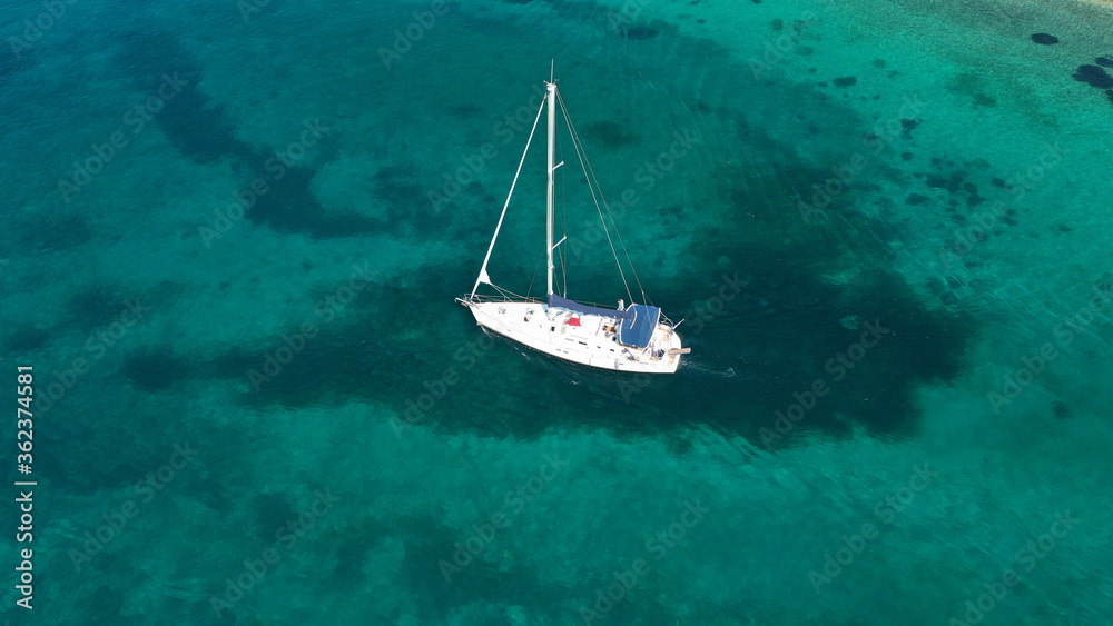 Aerial drone photo of sail boat cruising in the deep blue Aegean sea, Cyclades, Greece