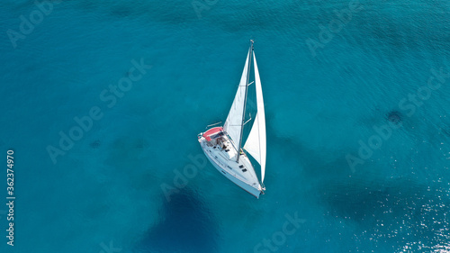 Aerial drone birds eye view of sail boat cruising the deep turquoise Aegean sea, Greece