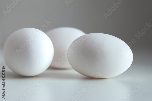 White chicken eggs on white background. Egg on table, natural healthy food. Creative minimalistic background. Concept organic farming and proper nutrition. Place for an inscription or logo