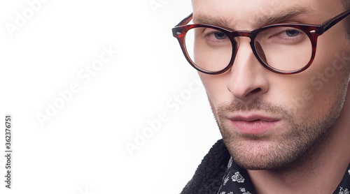 young bearded man in black jacket, pattern shirt and eyeglasses isolated on white background with copy space