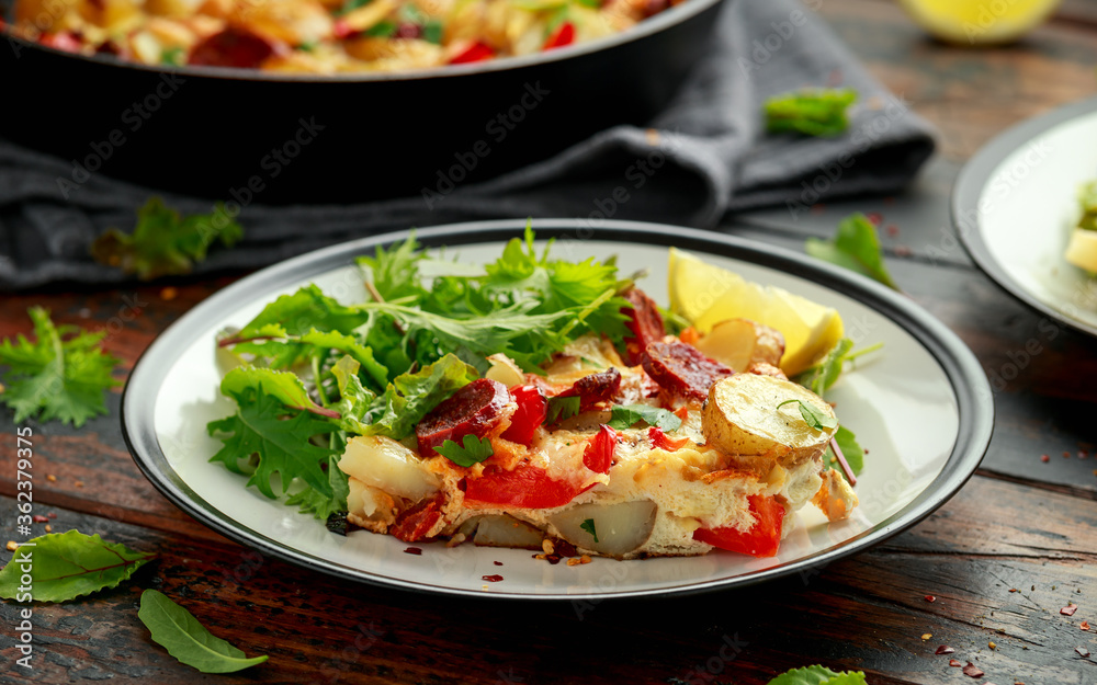 Chorizo Frittata with salad on black and white plate. healthy morning breakfast food