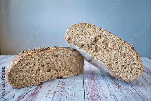 Wholemeal bread with chia seeds. Round bread cut in half with white background
