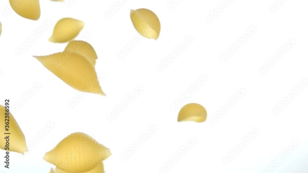 Dry pasta Conchiglie rigate flying diagonally on a white background in slow motion Dry pasta Conchiglie rigate flying diagonally on a white background in slow motion