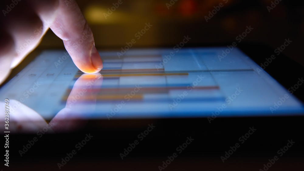 Fototapeta premium Businessman working in night office and using digital tablet