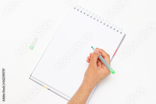Сhildren's hands hold the pen. Children writes in a notebook