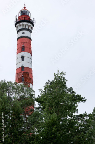 old tall Osinovetskiy lighthouse on a blue sky background on a coast of Ladoga lake