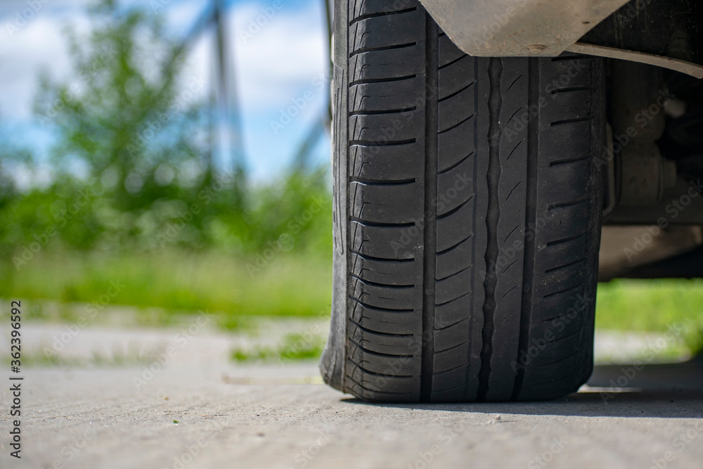View of the car wheel from below on the background of the road View of the car wheel from below on the background of the road