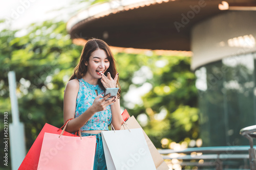 Smile young asian woman use online payment by credit card and smart phone.