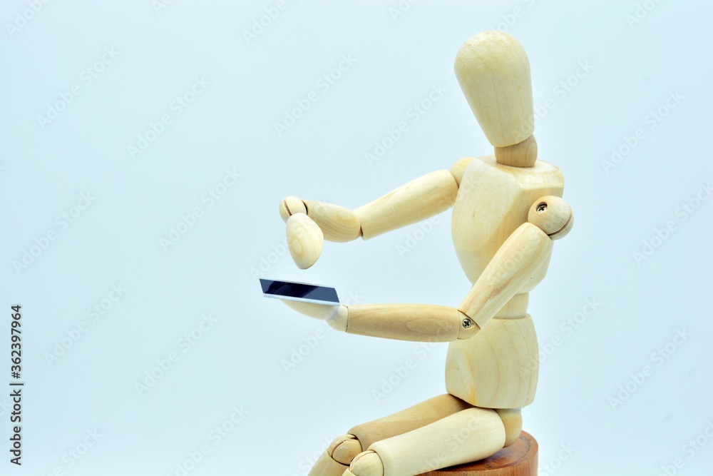 Maniquí de madera sentado, utilizando un teléfono móvil Maniquí de madera sentado, utilizando un teléfono móvil